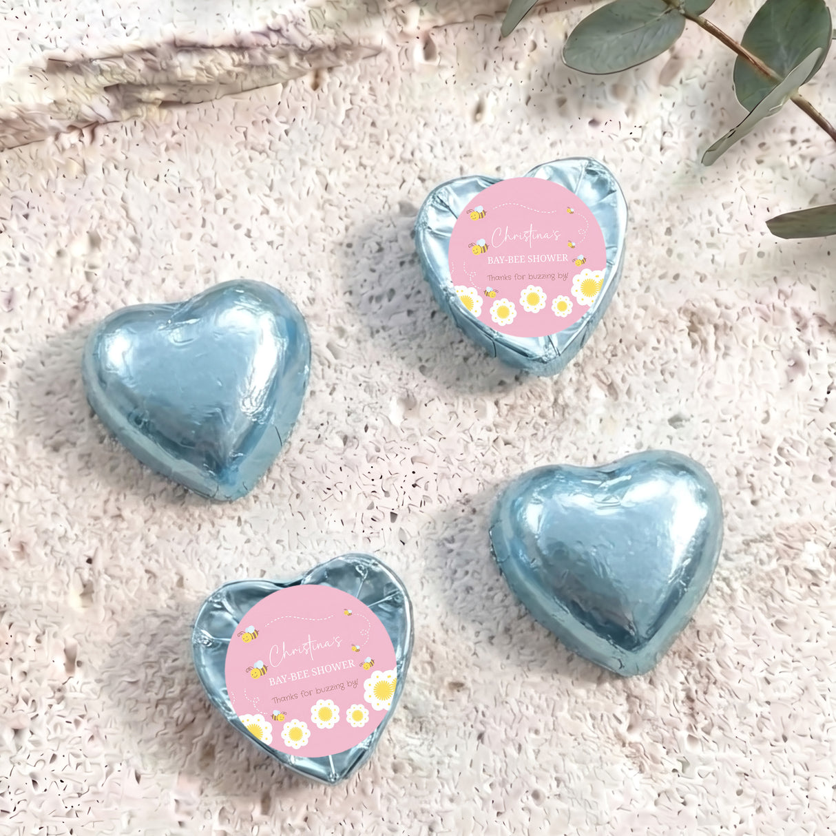 Blue foil heart chocolates with personalised baby-bee shower label on two hearts