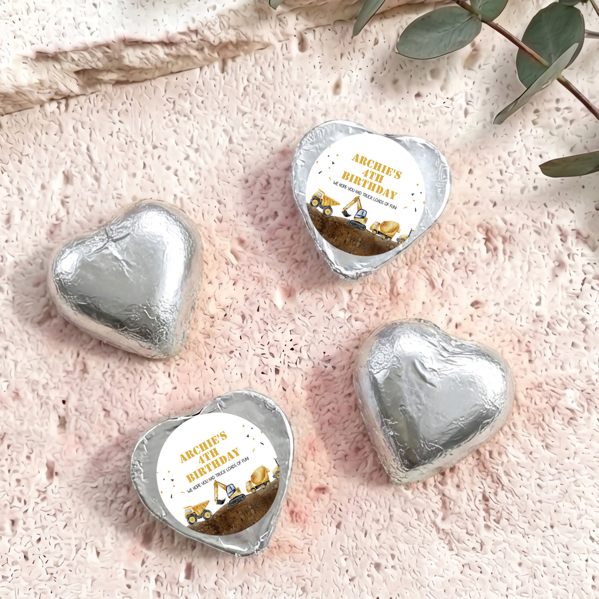 Foil-covered chocolate hearts in silver foil with birthday label featuring a construction truck