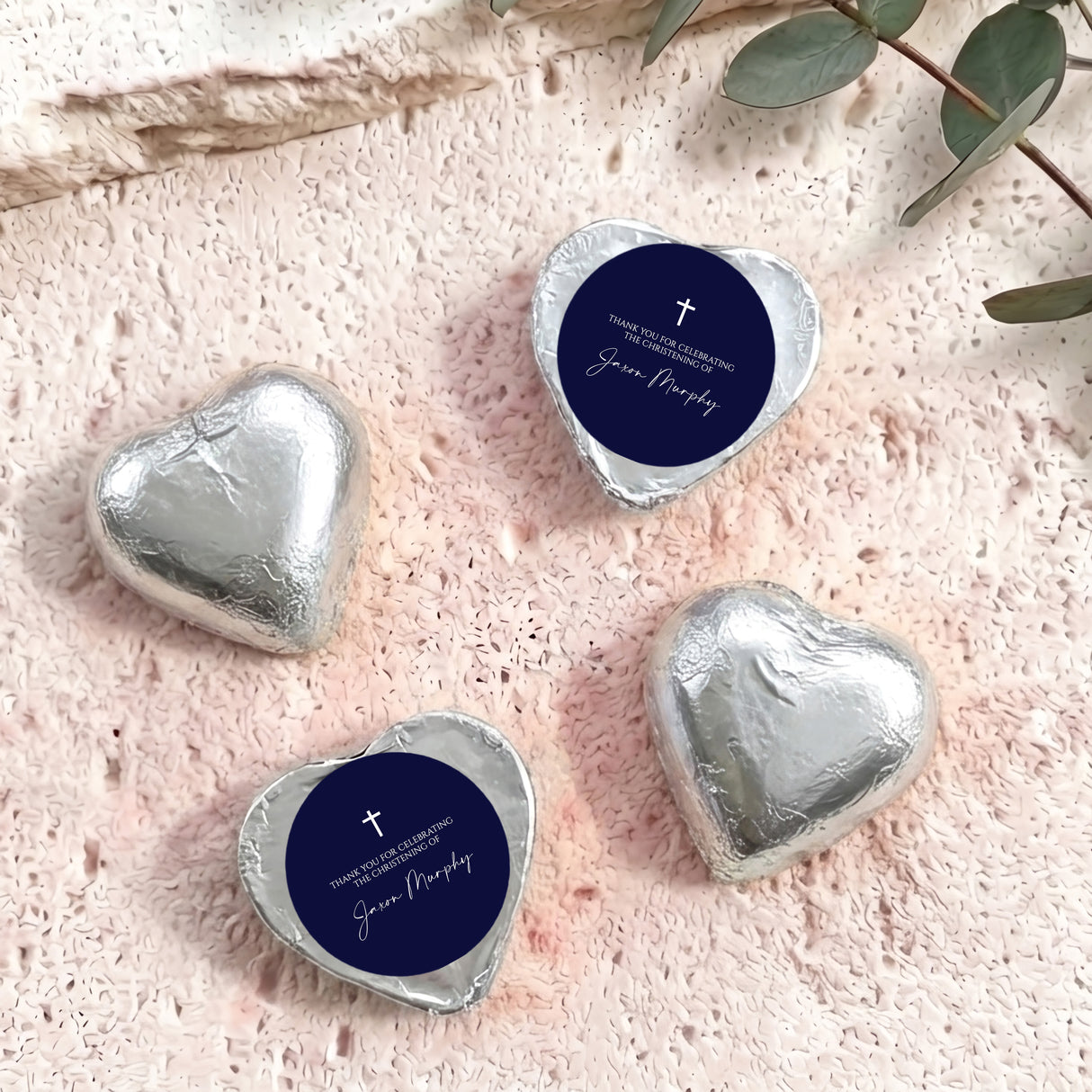 Foil-covered chocolate hearts, silver metallic with navy label and cross