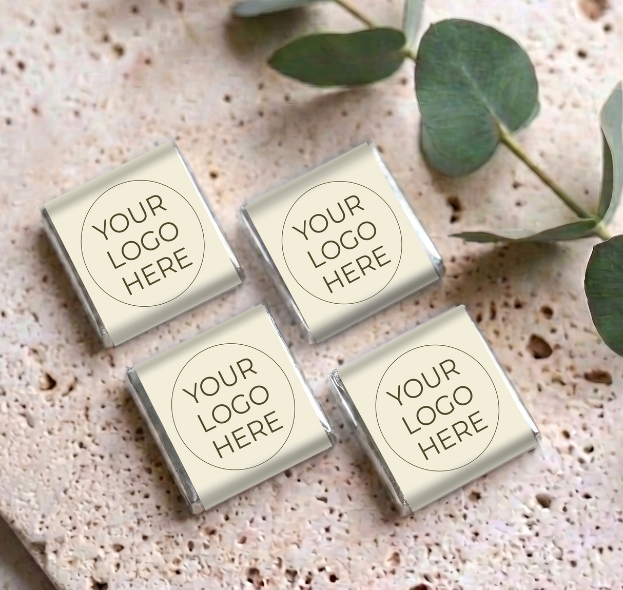 Four mini personalized chocolates with silver-foiled ends and “YOUR LOGO HERE” labels on cream wrappers