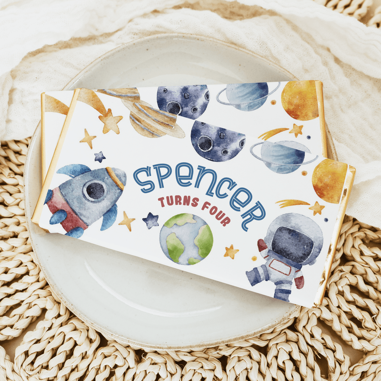 Space birthday chocolate bar wrapper with planets, astronaut, rocket, and 'Spencer turns four'
