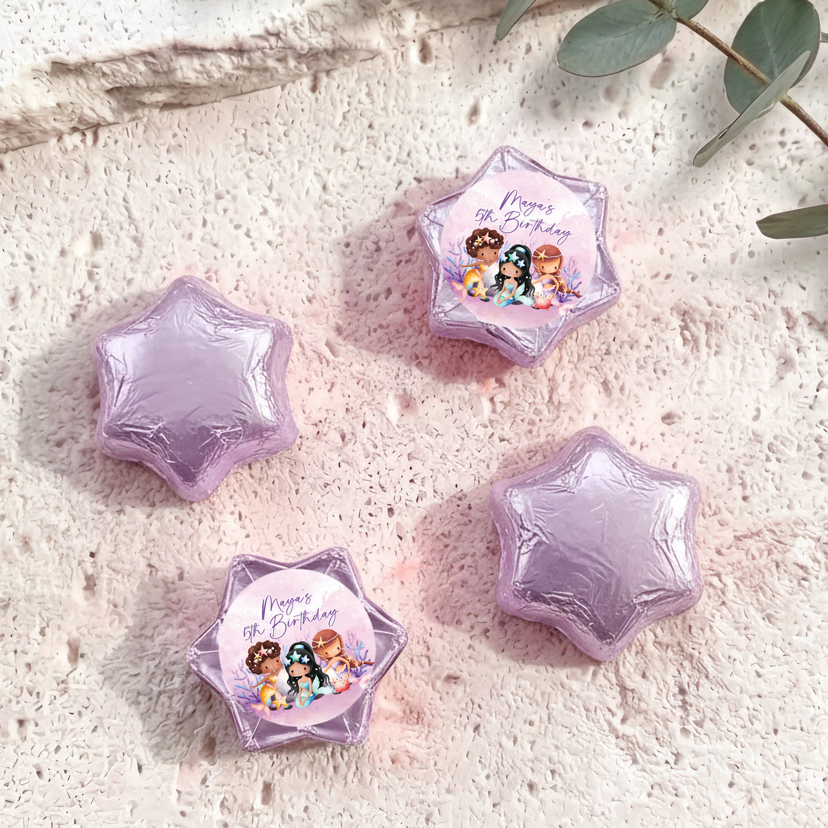 Lavender foil-covered chocolate stars, with a colorful mermaid birthday label star
