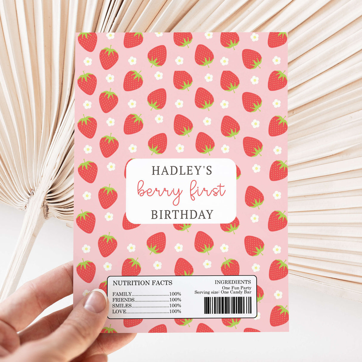 Strawberry-pattern chocolate wrapper with "Hadley's berry first Birthday" text and nutrition facts panel