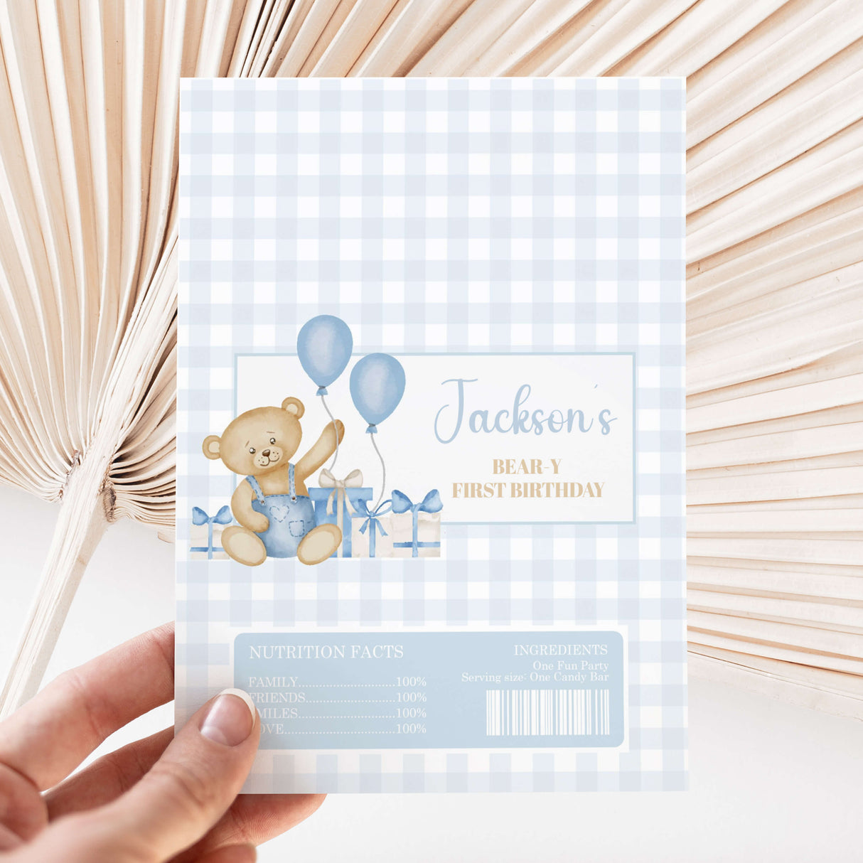 Light blue gingham chocolate wrapper with teddy bear holding balloons and 'First Birthday' text.