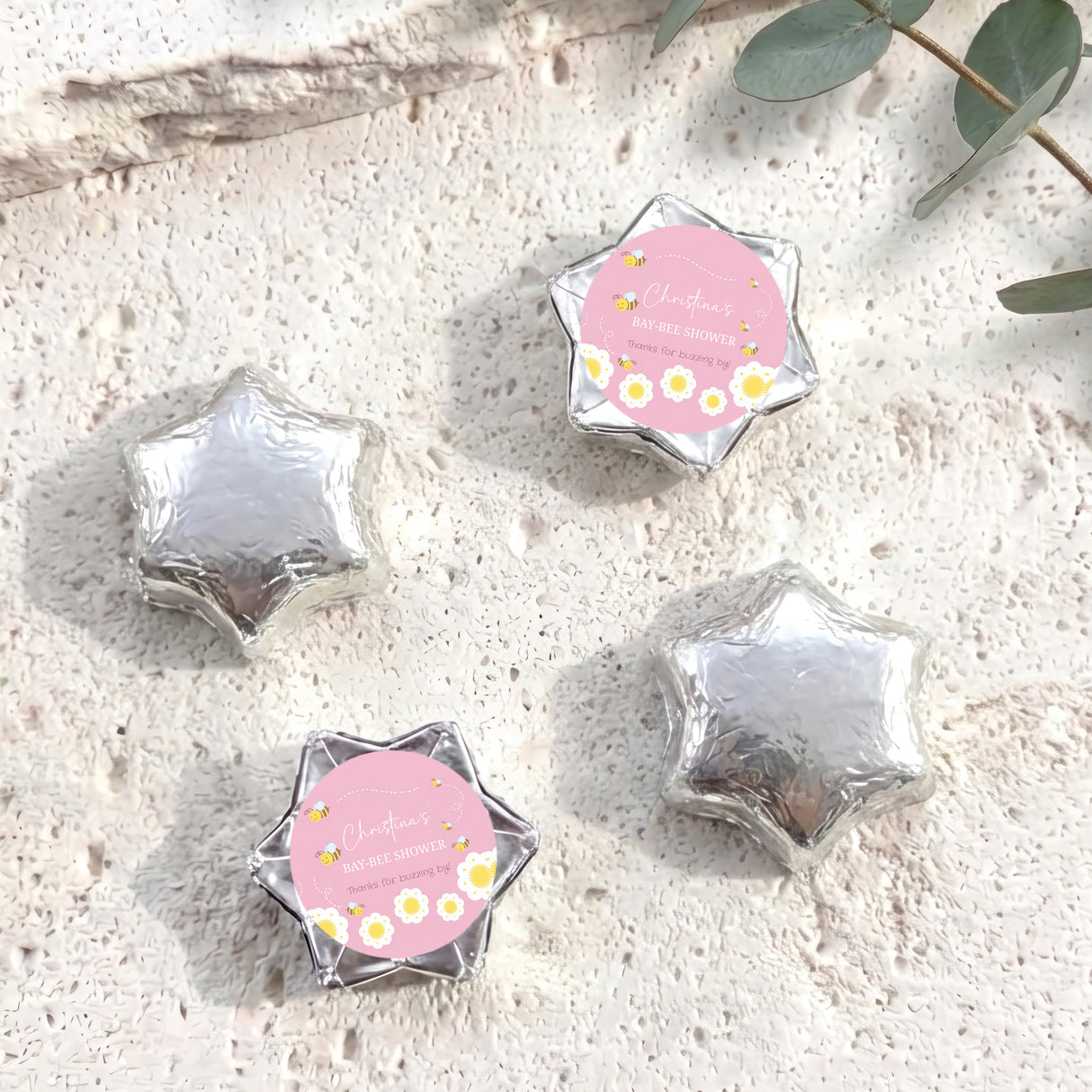 Silver foil chocolate stars with a pink hex label reading “May-Bee Shower”