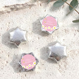 Foil-covered chocolate stars, silver set with pink “Happy” flower label