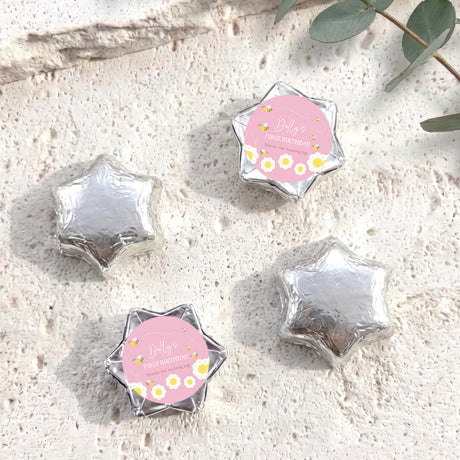 Silver foil-covered chocolate stars with “Dolly’s First Birthday” pink bee label
