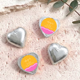 Silver foil heart chocolates with “Ange’s Baby Shower” label, wavy pink-orange stripe