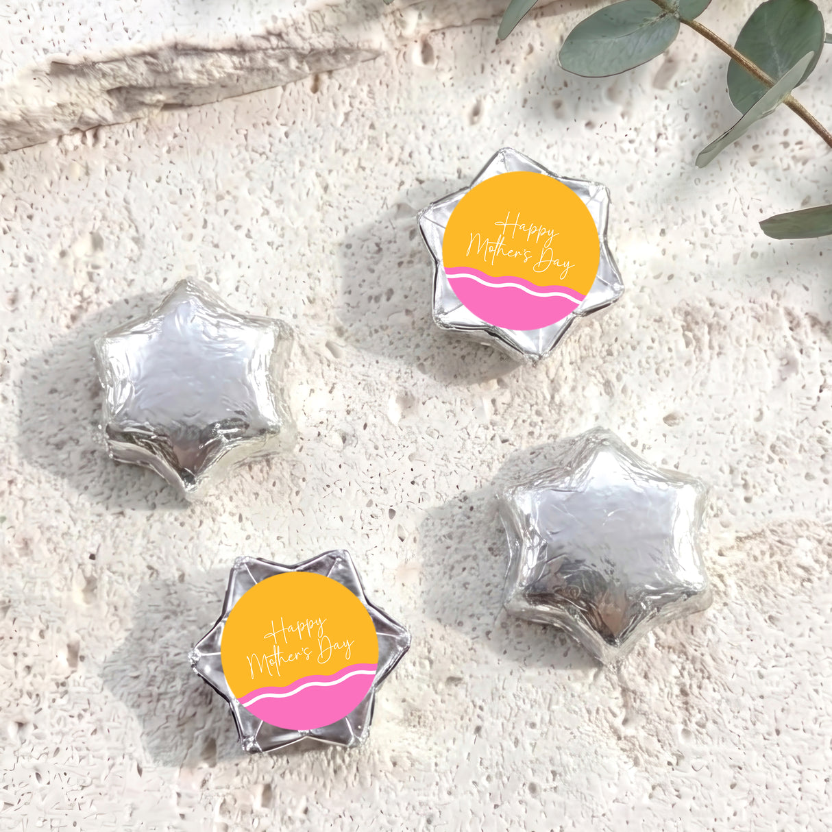 Silver foil star chocolates with “Happy Mother’s Day” label, arranged in set.