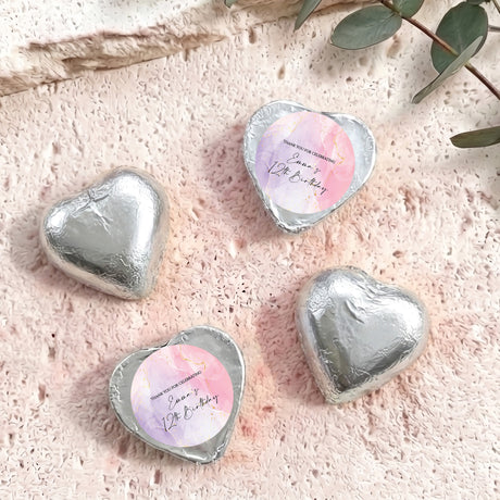 Silver foil-covered heart chocolates with round personalised labels on top