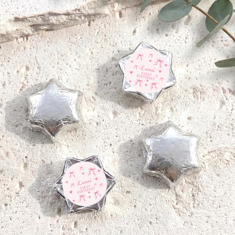 Foil-covered chocolate stars in silver, with “Luna’s First Birthday” round insert