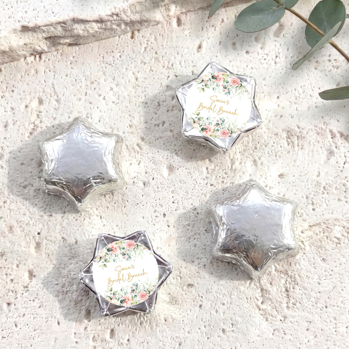 Foil-covered chocolate stars with silver foil and floral personalised label on top