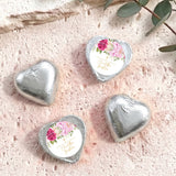 Heart-shaped foil-covered chocolate hearts in silver, with floral center labels