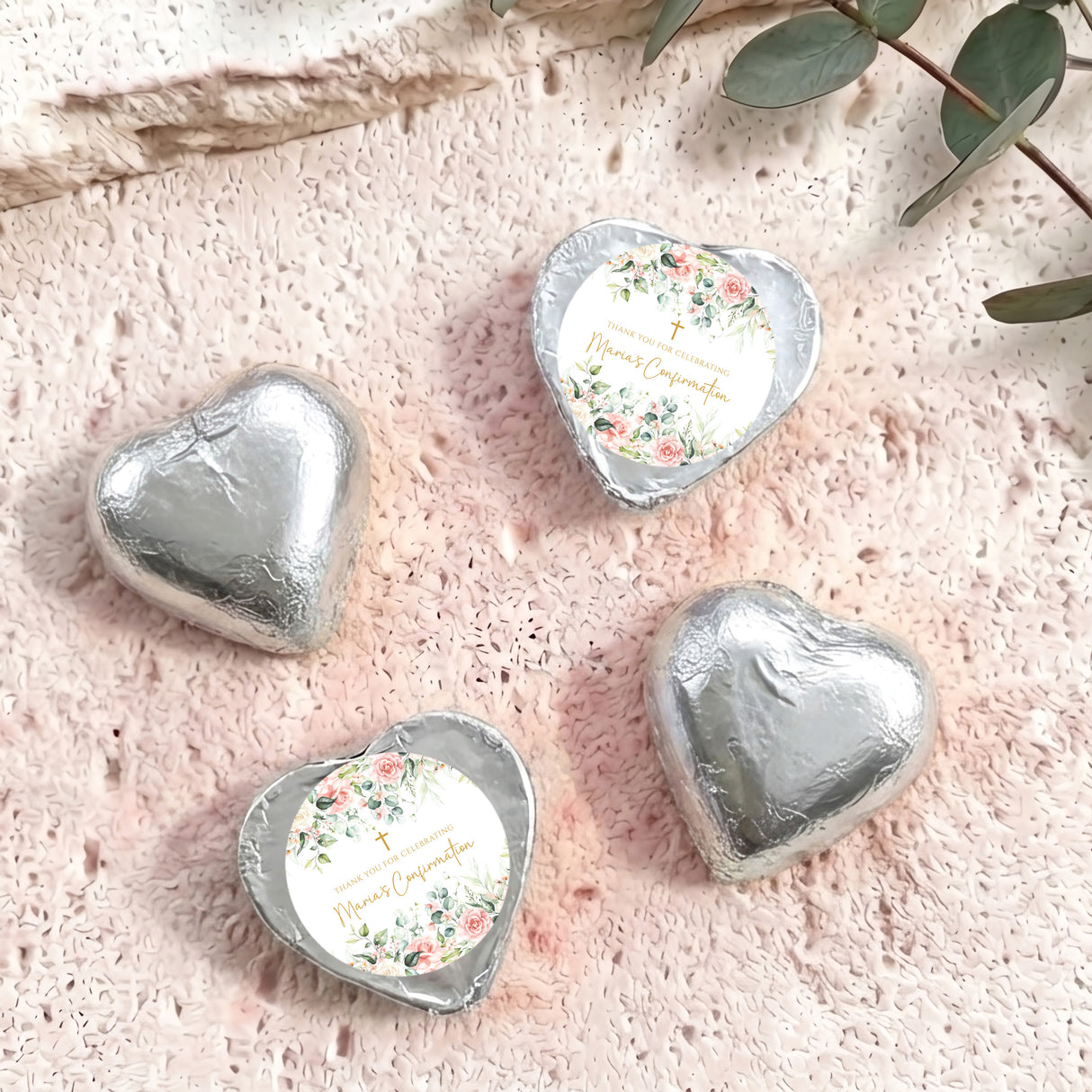 Silver foil confirmation chocolate hearts, one heart displays floral personalized message