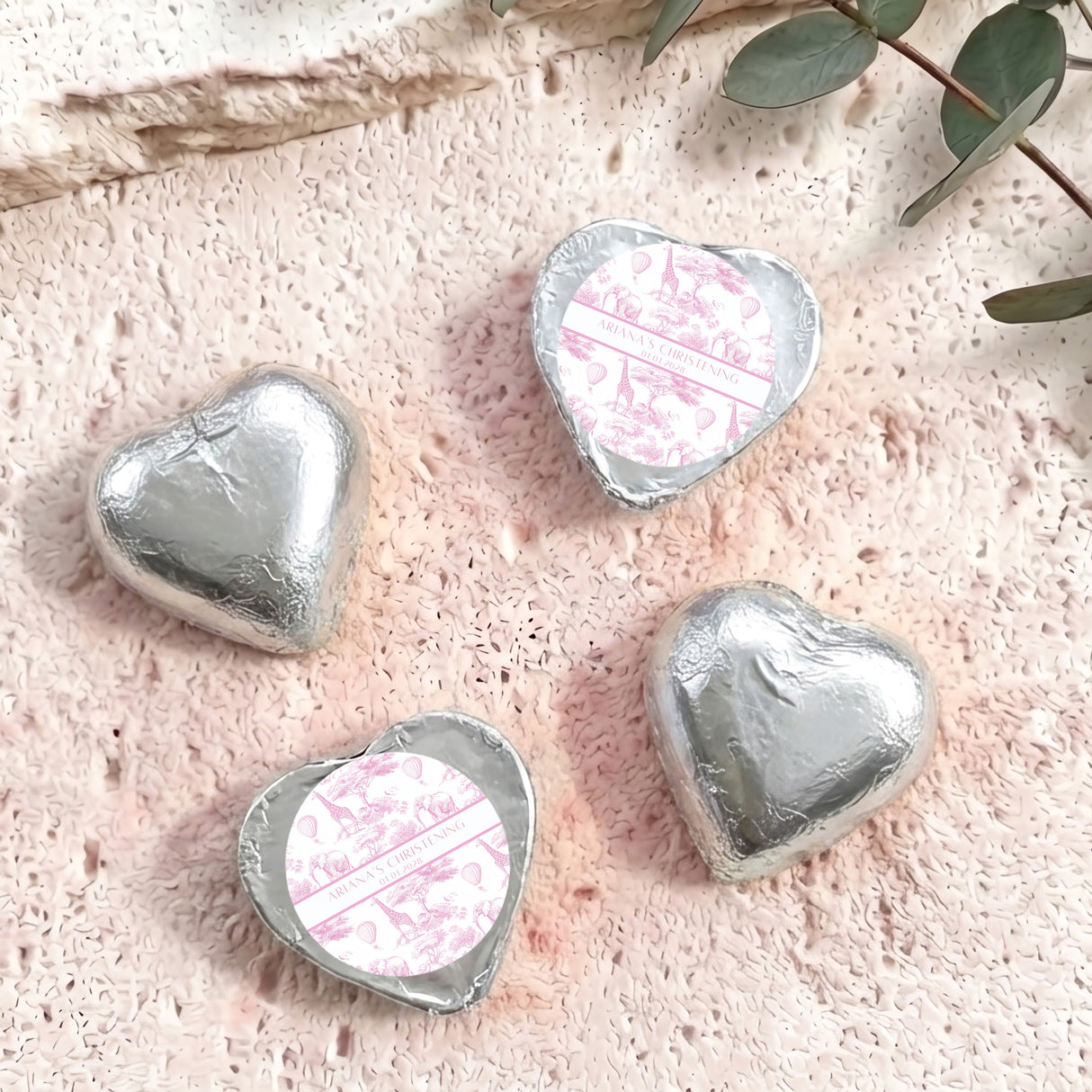 Silver and pink foil-covered chocolate hearts, with a personalised christening label heart
