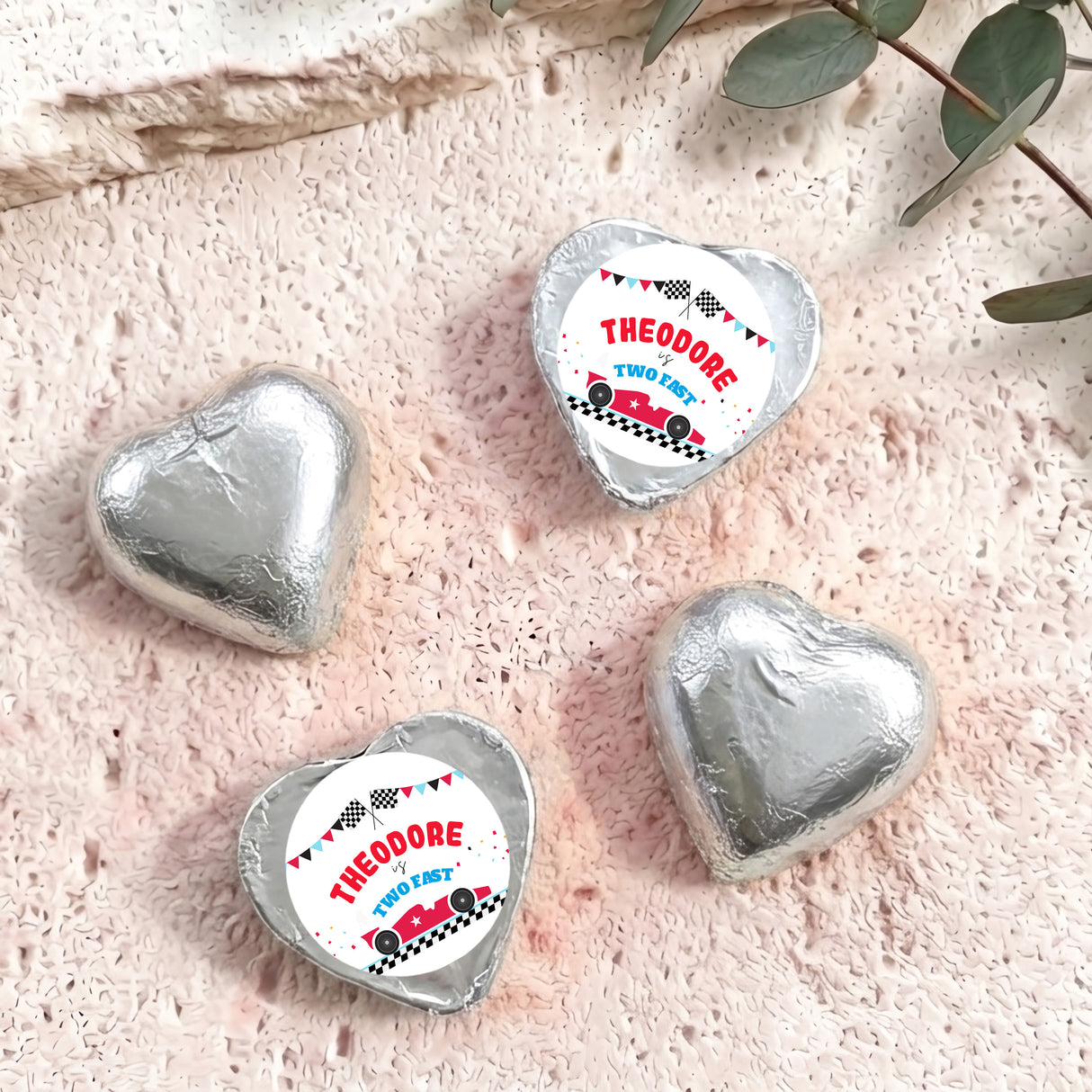 Silver foil-covered chocolate heart with “THEODORE TWO FAST” label