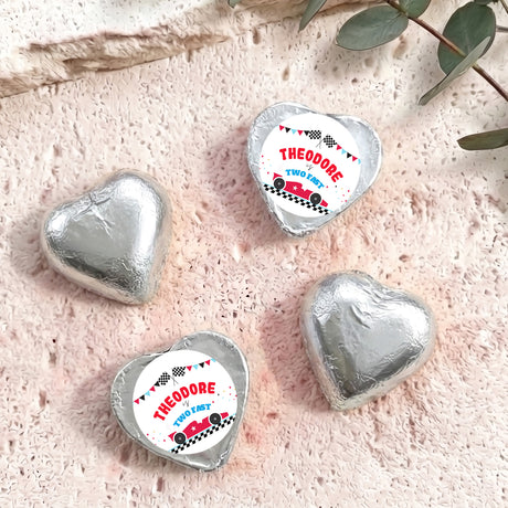 Silver foil-covered chocolate heart with “THEODORE TWO FAST” label