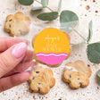 Personalised baby shower cookie favour in clear wrapper, held in hand, wavy label
