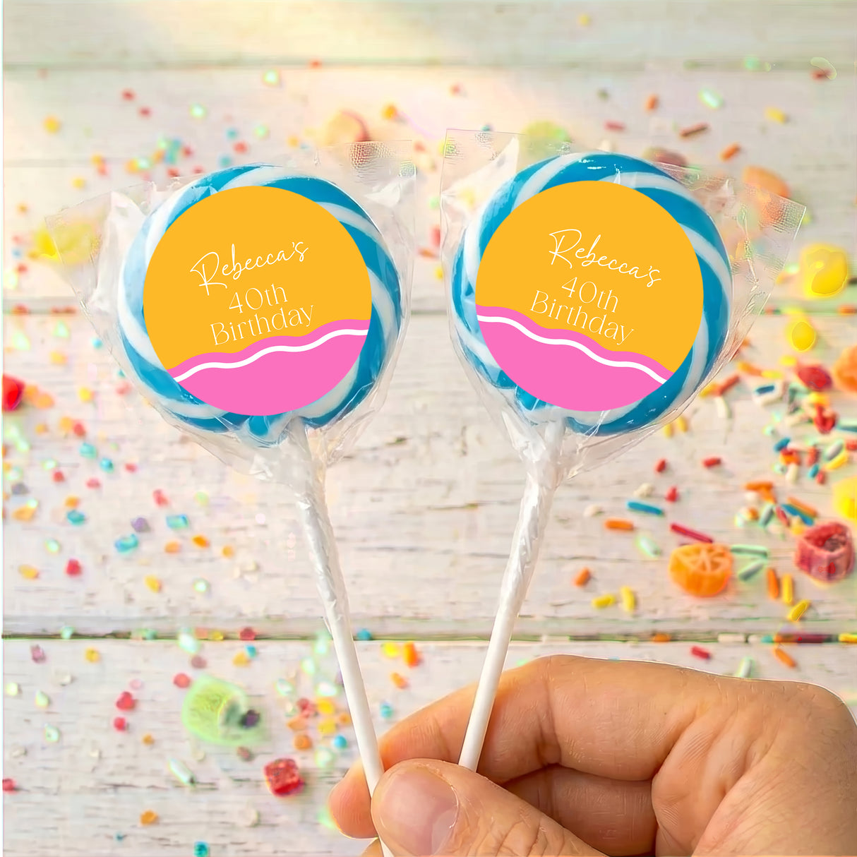 Personalised 40th birthday lollipops with blue-wrapped sticks and yellow-pink round labels