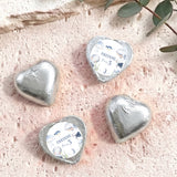 Personalised foil-covered silver chocolate hearts with name Freddie on a white label
