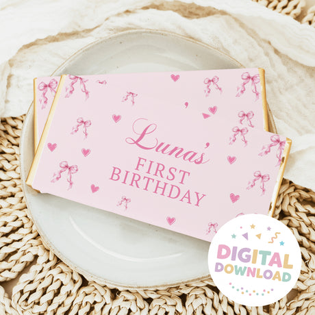 Pink chocolate bar wrapper with bows, hearts, and 'Luna's First Birthday'
