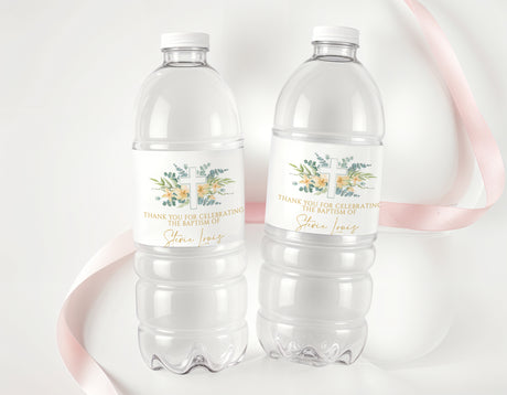 Two clear plastic water bottles with personalised baptism labels, cross and eucalyptus.