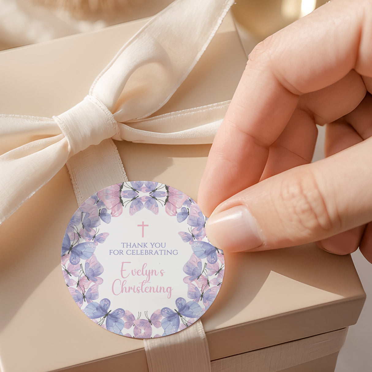Round baptism thank-you label with pink and purple butterflies, cross, and text