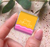 Mother's Day mini chocolates, yellow and pink wavy boxes held close-up