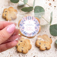 Hand-held decorated cookie with purple butterfly round thank-you label, “Evelyn’s Christening”