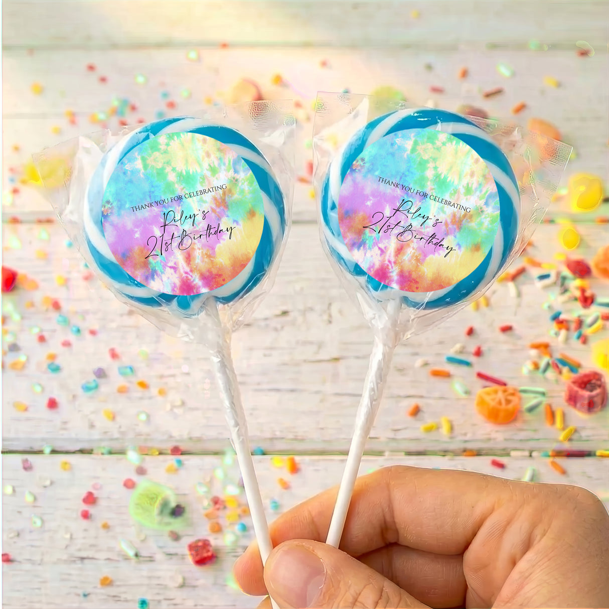 Personalised tie-dye lollipop pair with colorful circular labels on clear sticks