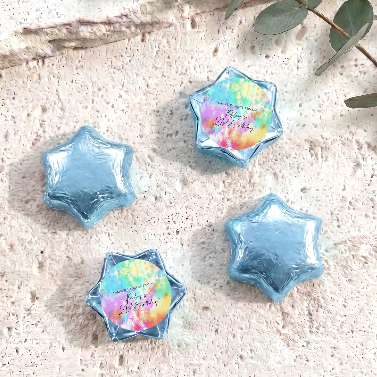 Foil-covered star chocolates in light blue with one pastel tie-dye foil star