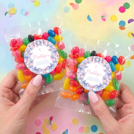 Two jelly bean bags with circular butterfly labels, held in hands over confetti