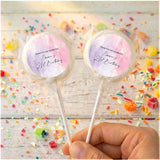 Personalised birthday lollipops with pink swirled wrappers, held by hand
