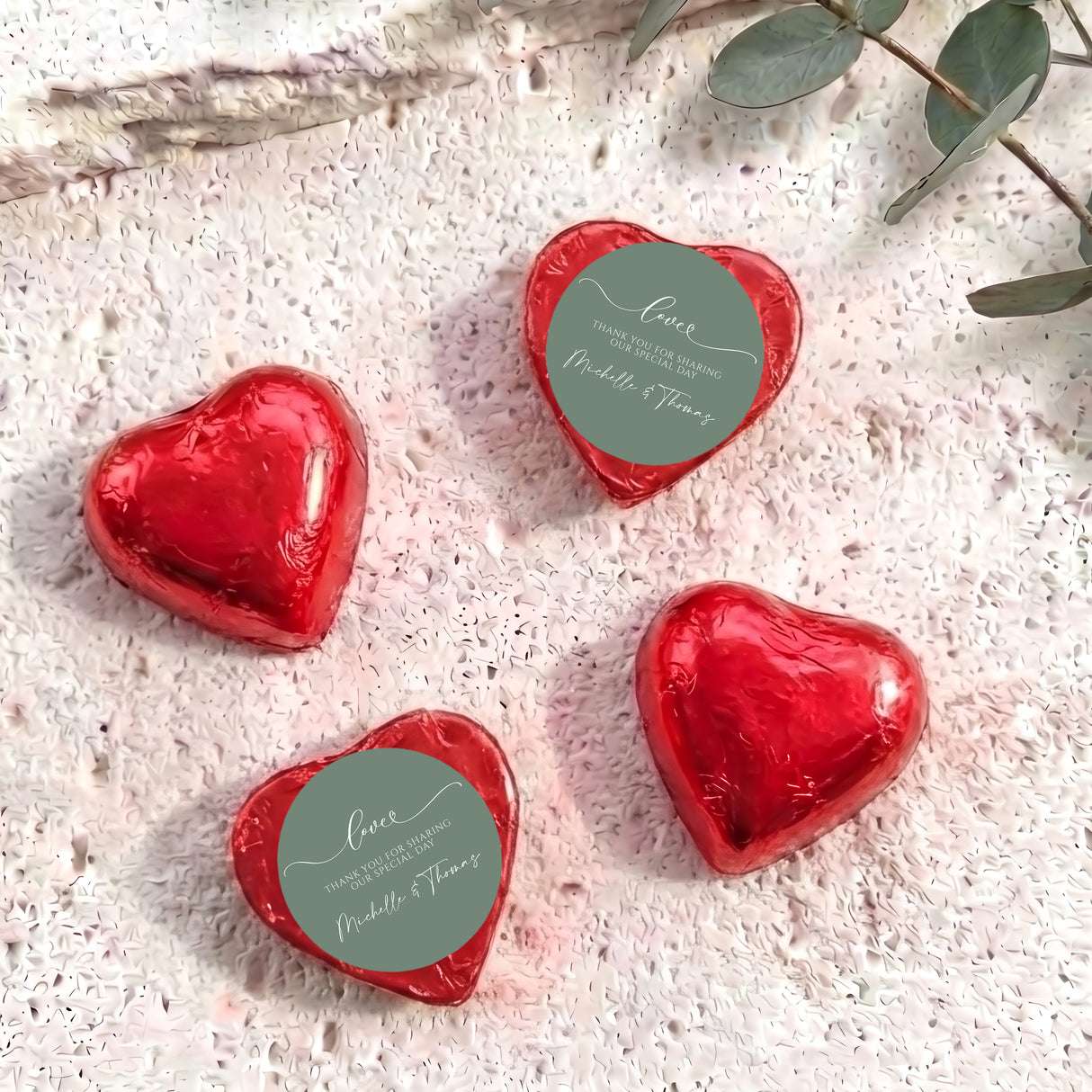 Red foil-covered heart chocolates with round personalized thank-you labels