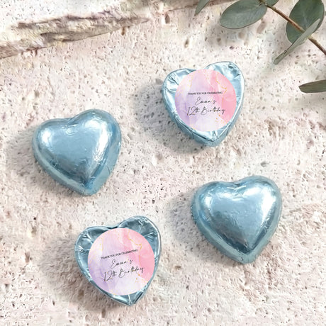 Light blue foil-covered heart chocolates with round personalised labels on top