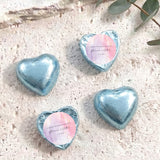 Foil-covered chocolate heart in light blue with round white name label and foil rim