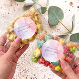 Pink-purple sticker personalised popcorn bag; clear bag of colorful popcorn