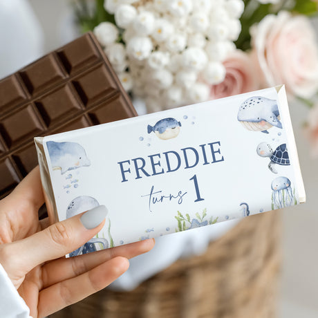 Ocean-themed chocolate bar wrapper with 'FREDDIE turns 1' text and sea creature prints