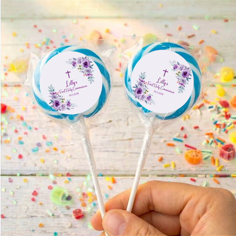Blue-wrapped personalised lollipops with purple rose First Holy Communion labels