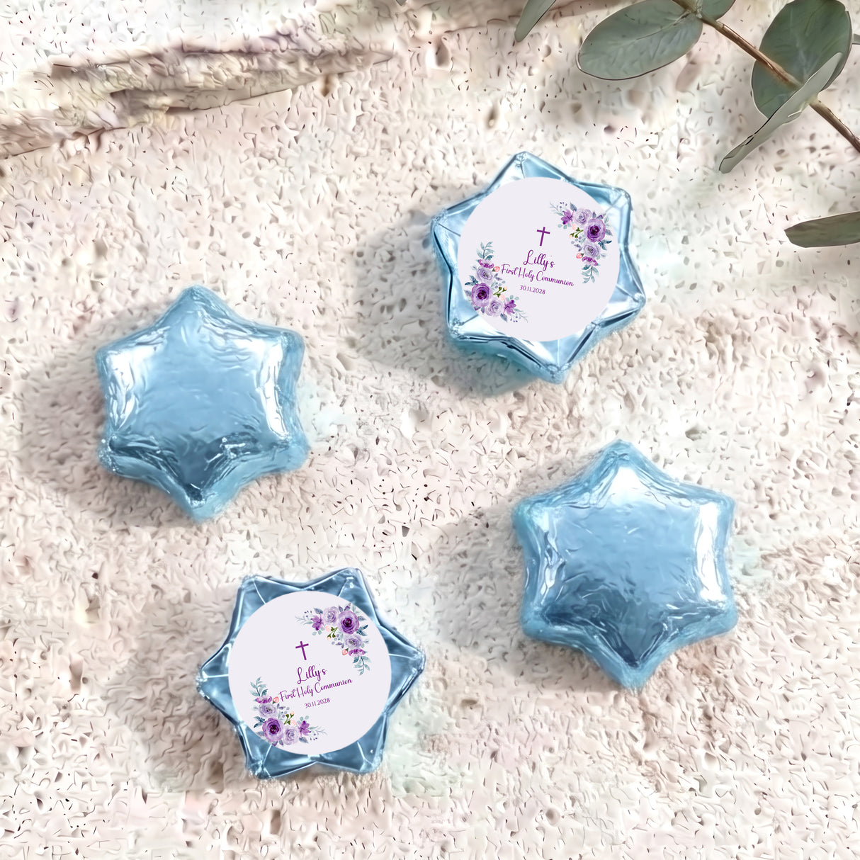 Foil-covered chocolate stars in light blue with a First Holy Communion-style label