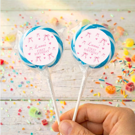 Blue ribbon bow lollipops with round “Luna’s First Birthday” labels