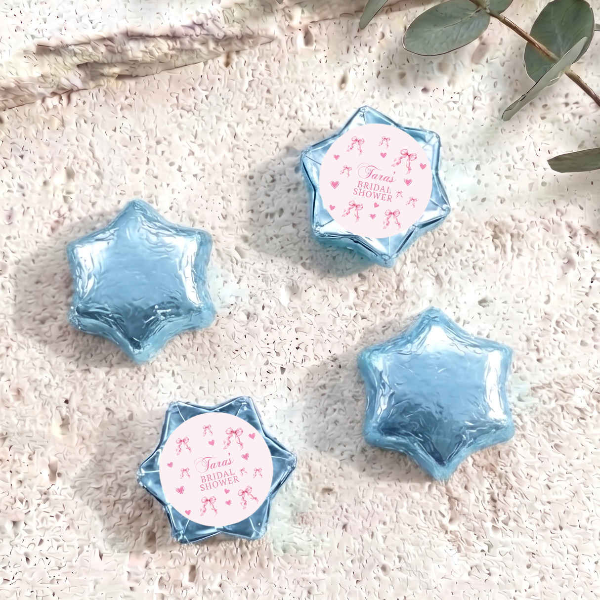 Blue foil-covered chocolate stars with personalised party label on blue patterned insert
