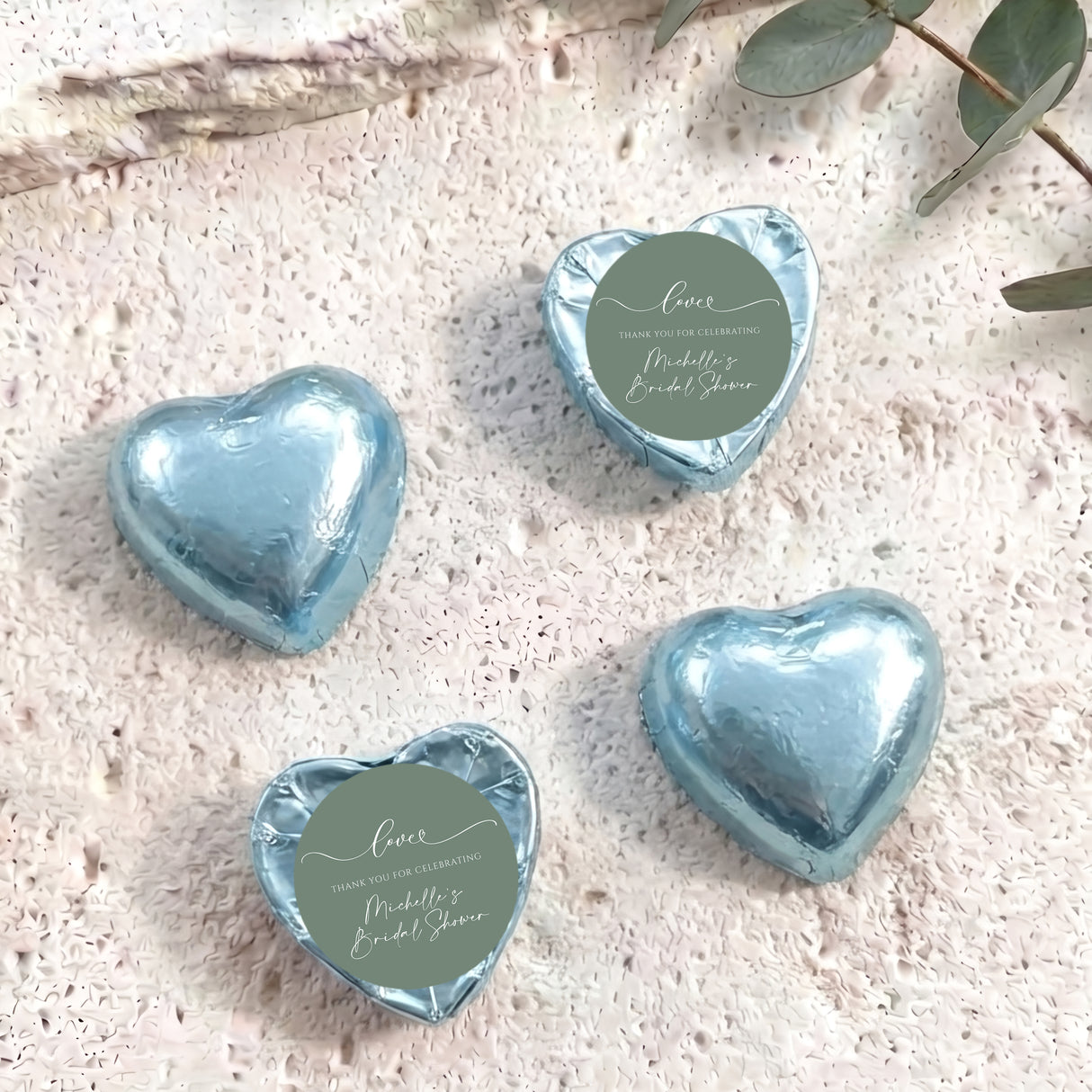 Light blue heart-shaped foil-covered chocolate hearts with round thank-you label