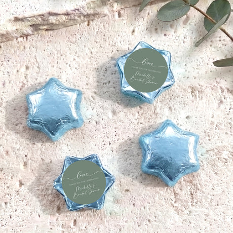 Foil-covered chocolate stars, light blue with round personalized label