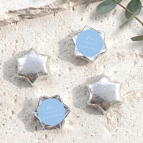 Silver foil-wrapped chocolate stars with round personalized label discs