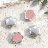 Set of silver foil-covered chocolate stars with a pink heart label
