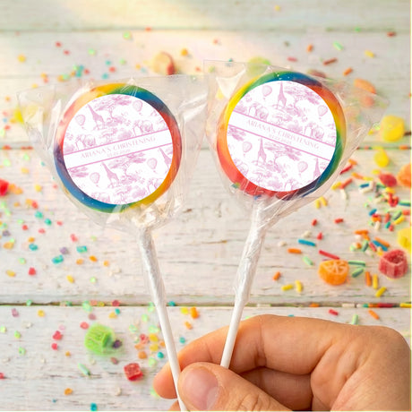 Rainbow swirl lollipops with round personalized Christening labels on clear wrapped sticks