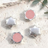 Silver foil-covered chocolate stars, star-shaped foil chocolates with round label.