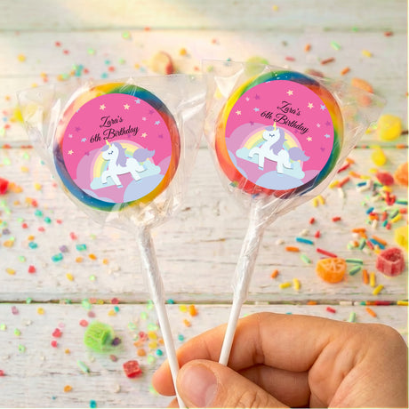 Two unicorn lollipops, 'Zara's 6th Birthday' pink round labels, rainbow trim