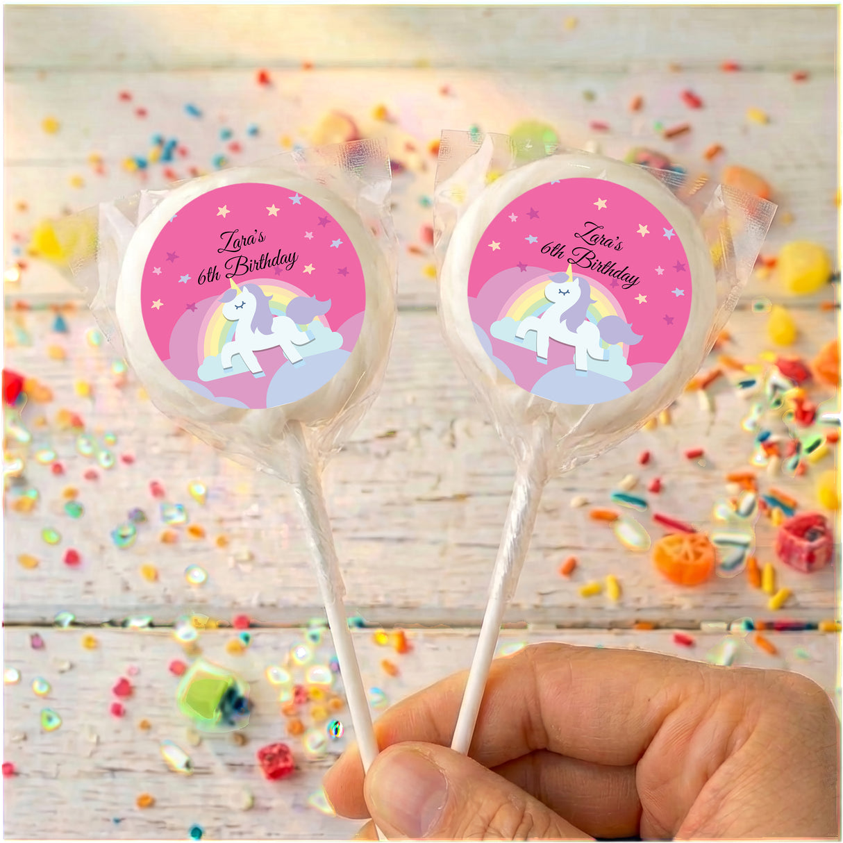 Two unicorn lollipops, 'Zara's 6th Birthday' pink labels with white outer ring